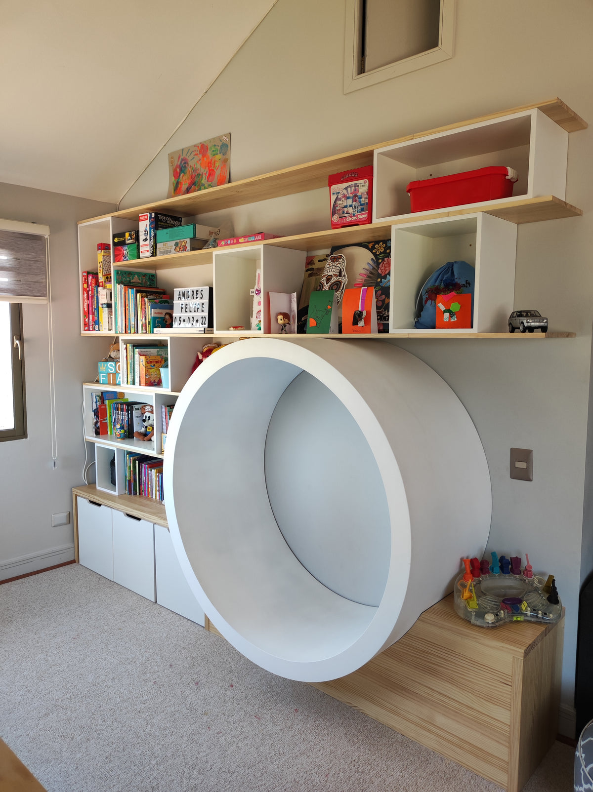 Mueble infantil a medida con espacio circular de juego, repisas para libros y cajones de guardado