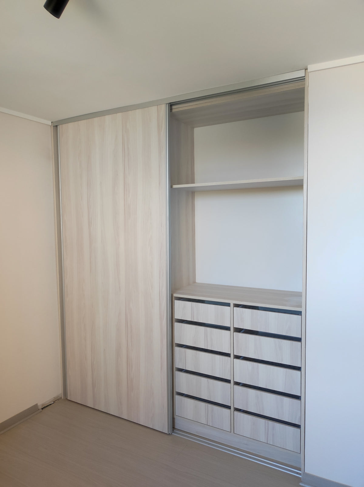 Clóset a medida con puertas correderas en melamina clara y cajonera interior de diez cajones